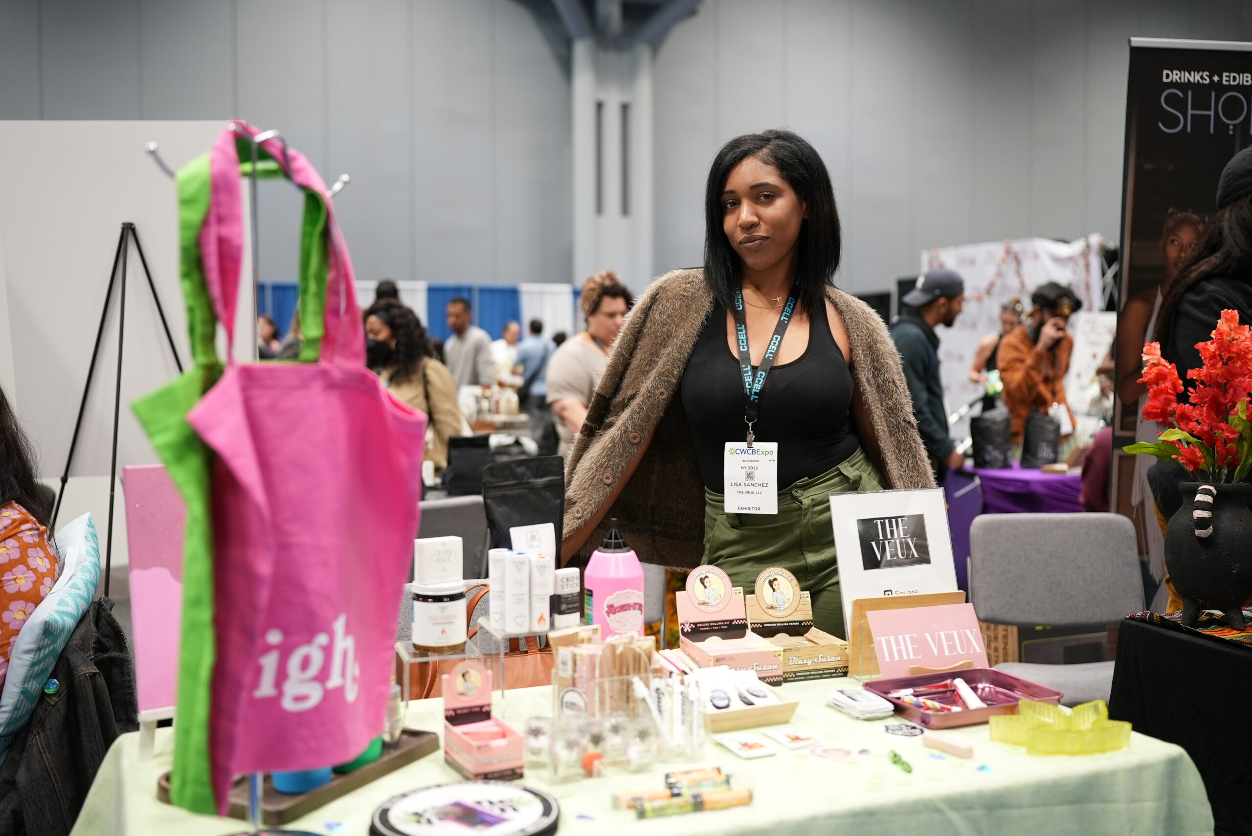 Business owner poses with table of merchandise at CWCBExpo 2022 Womens Pavilion